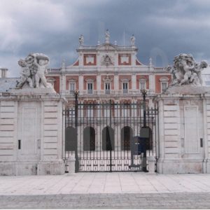 Detalle de la fachada del Palacio Real de Aranjuez desde la Plaza Elíptica (o de la Parada de Palacio), con primer plano de detalle escultórico de la verja de cierre del Patio de Armas.