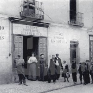 Varios niños y adultos delante de una tahona en la calle Gobernador de Aranjuez