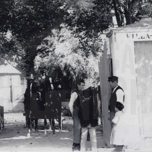 Dos hombres conversan a la entrada de la finca Villa Mata  en Aranjuez mientras sale un coche de caballos