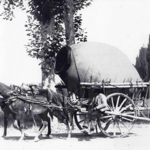 Un hombre transporta una tinaja de grandes dimensiones en una carreta