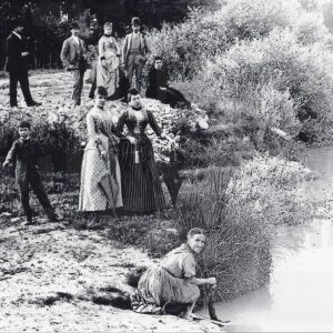 Varias personas junto al río Tajo mientras una mujer lava en él la ropa