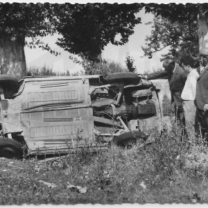Tres hombres mirando un coche accidentado en Aranjuez