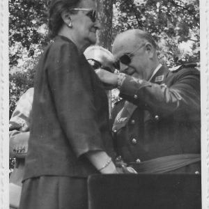 General de brigada poniendo una insignia a una mujer