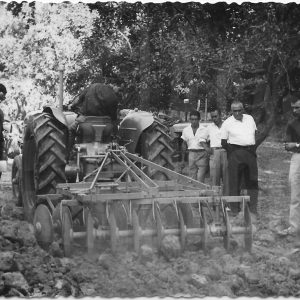 Hombres contemplando el arado de un tractor