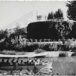 Personas en un barco por el río Tajo en Aranjuez, al fondo El Castillo