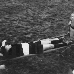 Dos operarios de la Cruz Roja retiran en camilla a un árbitro de un campo de fútbol