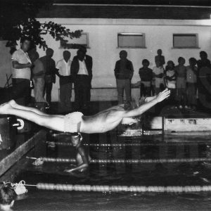 Nadador saltando a la piscina en una competición de natación