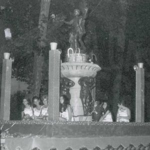 Varias jóvenes en una carroza con una fuente