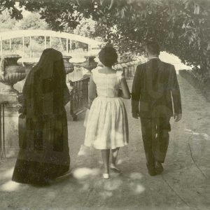 Tres personas de espaldas, caminando en el Jardin del Parterre de Aranjuez, con el Puente de Barcas al fondo