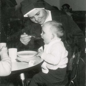 Una monja dando de comer a un niño en Aranjuez