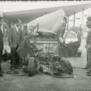 Cinco varones observan un coche accidentado cerca de una gasolinera en Aranjuez