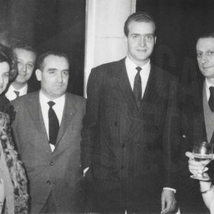 El príncipe Juan Carlos y otras personas en una recepción durante la visita oficial a la fábrica de MAFE (Manufacturas Fotográficas Españolas) en Aranjuez