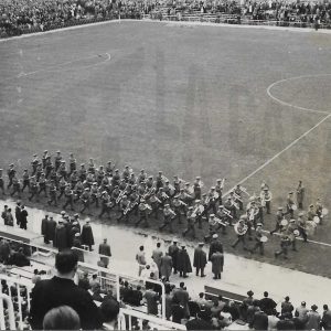 Desfile de una banda de música en un campo de futbol