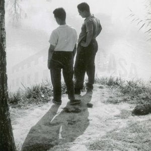 Dos hombres en la orilla de un río