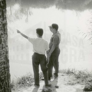 Dos hombres en la orilla de un río