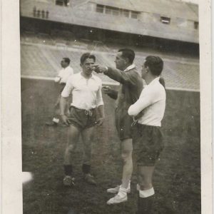 Un entrenador da indicaciones a los jugadores en un entrenamiento de fútbol en un estadio sin público