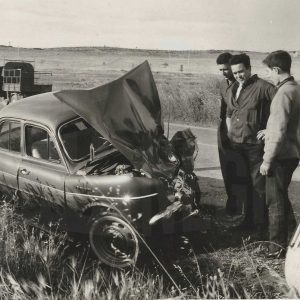 Automóvil accidentado en carretera y varias personas a su alrededor