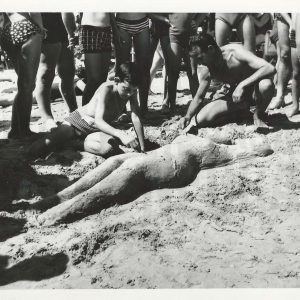 Padre e hijo haciendo una escultura de arena en la playa.