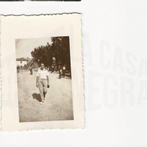 Un hombre caminando con el antiguo Puente de Barcas detrás, en Aranjuez