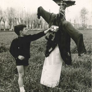 Niño con un espantapájaros en el campo