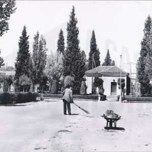Un señor barriendo en la calle Príncipe, frente a la antigua Oficina de Turismo en Aranjuez