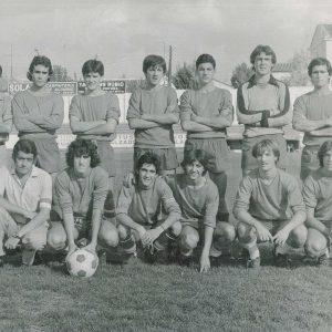 Un equipo de fútbol y otras dos personas posando en el campo de fútbol de Aranjuez