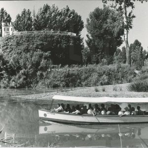 Un barco turístico surca el río Tajo a su paso por El Castillo en Aranjuez