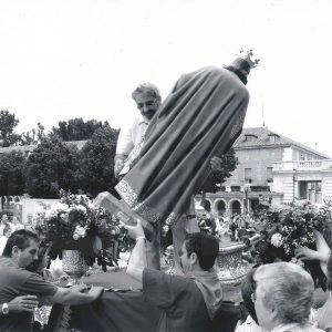 Un hombre sostiene la imagen de San Fernando en la puerta de la iglesia de San Antonio en Aranjuez