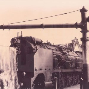 Locomotora antigua de carbón cargando agua en la Estación de Aranjuez