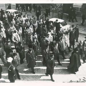 Comitiva con autoridades y otras personas por una calle