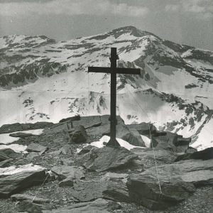 Cruz en la cima de una montaña nevada