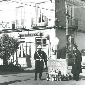 Dos guardias municipales recogiendo el aguinaldo junto a un cartel felicitando las pascuas en Aranjuez