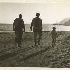 Dos hombres y una niña paseando por la playa