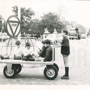Varios niños en un carro en la Plaza de San Antonio en Aranjuez con el Puente Barcas y el Jardín del Parterre al fondo