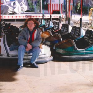 Niña sentada en los coches de choque