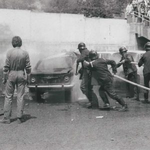 Bomberos apagando un fuego en una demostración automovilística