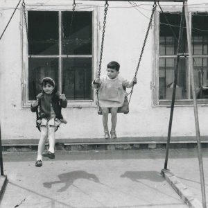 Los hijos de Antonio Talavera jugando en un columpio en un patio