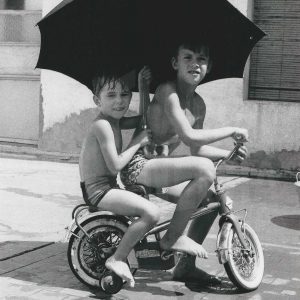 Niños jugando con una bicicleta en un patio