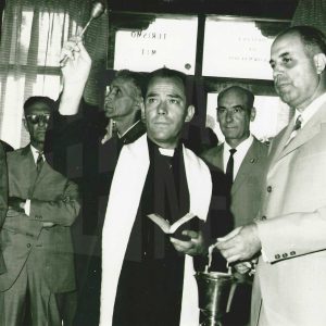 Un saderdote bendice con un hisopo la nueva Oficina de Turismo de Aranjuez