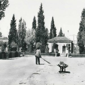 Un trabajador barriendo la calle junto a la primera Oficina de Turismo en Aranjuez