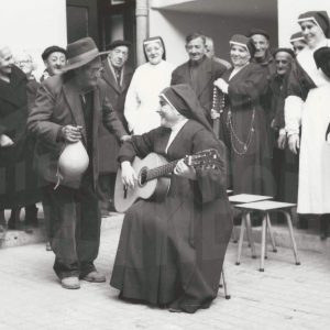 Monja acompañando a la guitarra a un residente del Asilo de San Isidro en Aranjuez