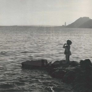 Perfil de una niña a contraluz frente al mar en la costa de Alicante