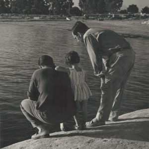 Dos hombres y una niña miran las aguas de un río