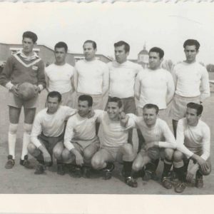 Equipo de fútbol de MAFE (Manufacturas Fotográficas Españolas) en el antiguo Campo de Fútbol de la Calle Foso de Aranjuez. Al fondo el Colegio Público San José de Calasanz y cúpula de la Iglesia de Alpajés