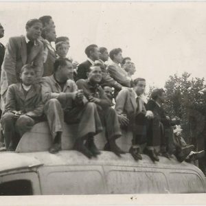 Grupo de personas subidas en el techo de una furgoneta