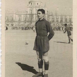Futbolista del Aranjuez C.F. en el Campo de Fútbol de las Tablas en la Plaza de Parejas de Aranjuez. Al fondo el Palacio Real.