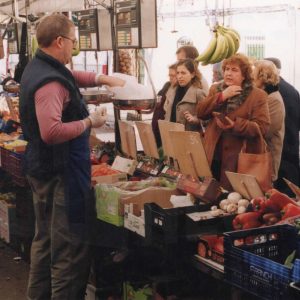 Clientes comprando en puesto de fruta en el Rastro de Aranjuez