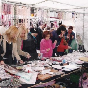 Varias personas delante de un puesto de bisutería en el Rastro de Aranjuez