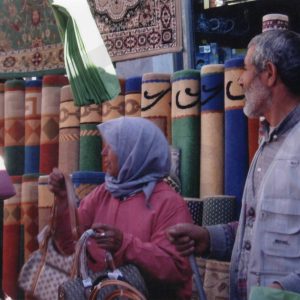 Vendedores en un puesto de alfombras y bolsos en el Rastro de Aranjuez