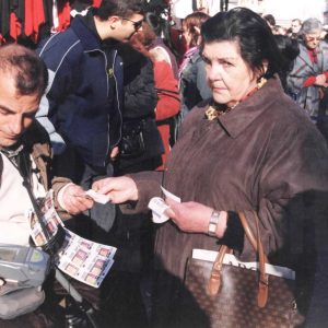 Vendedor de lotería de la ONCE con una clienta en el Rastro de Aranjuez